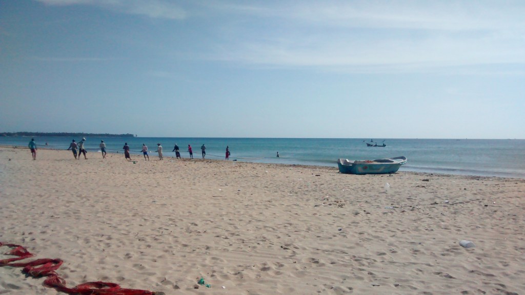 Los pescadores de Uppuveli sacan las redes tirando de ellas formando una fila en la arena.